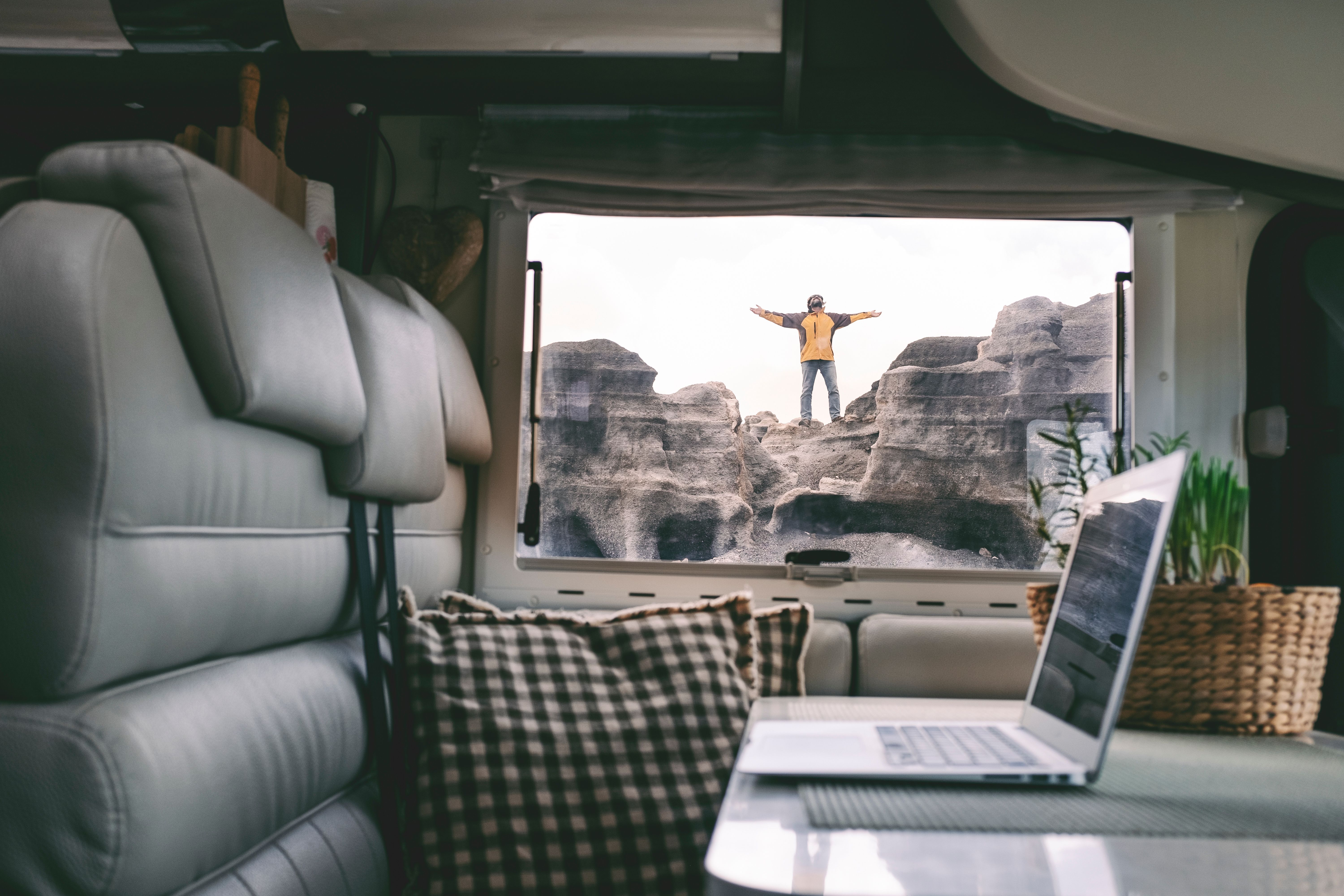 digital nomad standing outside his compact travel trailer similar to van life